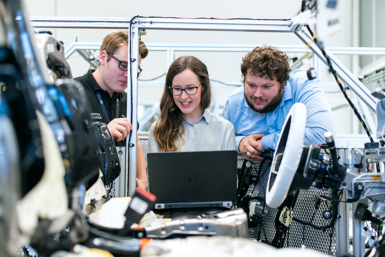 Engineers examining a vehicle project in an automotive workshop
