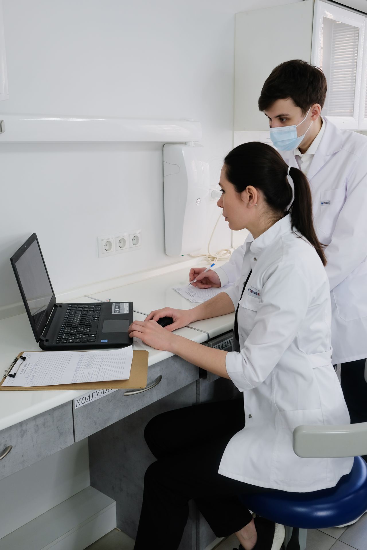 Healthcare professionals studying information together on a laptop