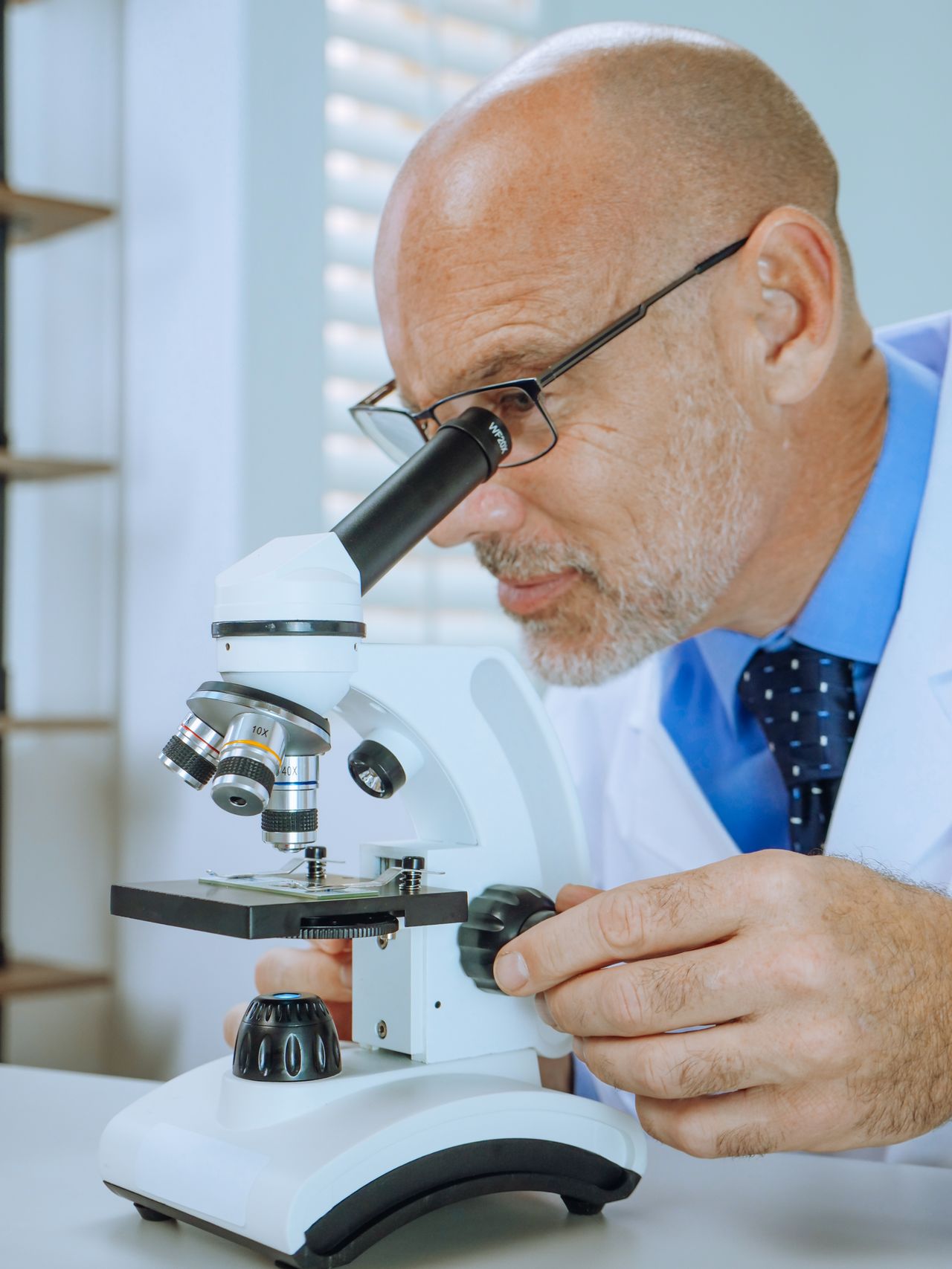A scientist examining a microscope slide in a laboratory