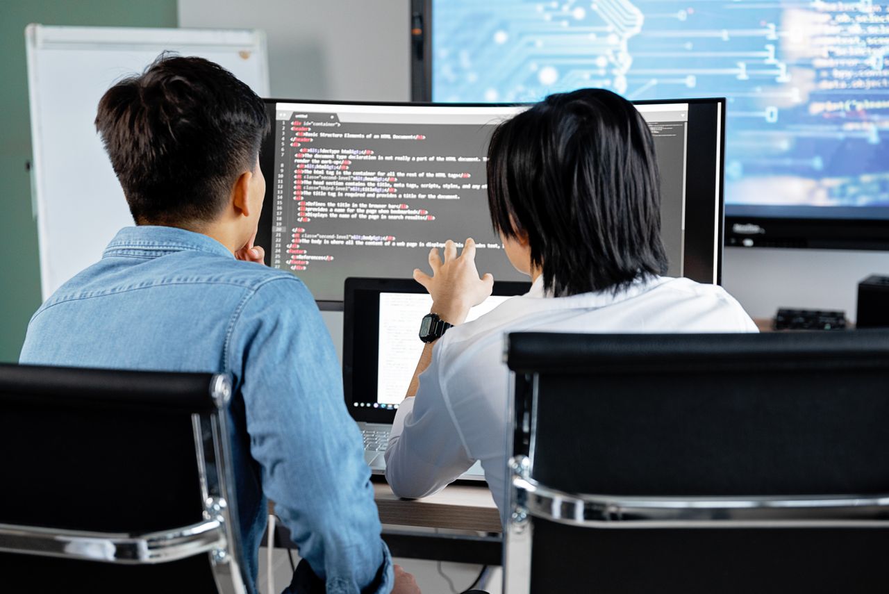 Two developers reviewing code together at a computer