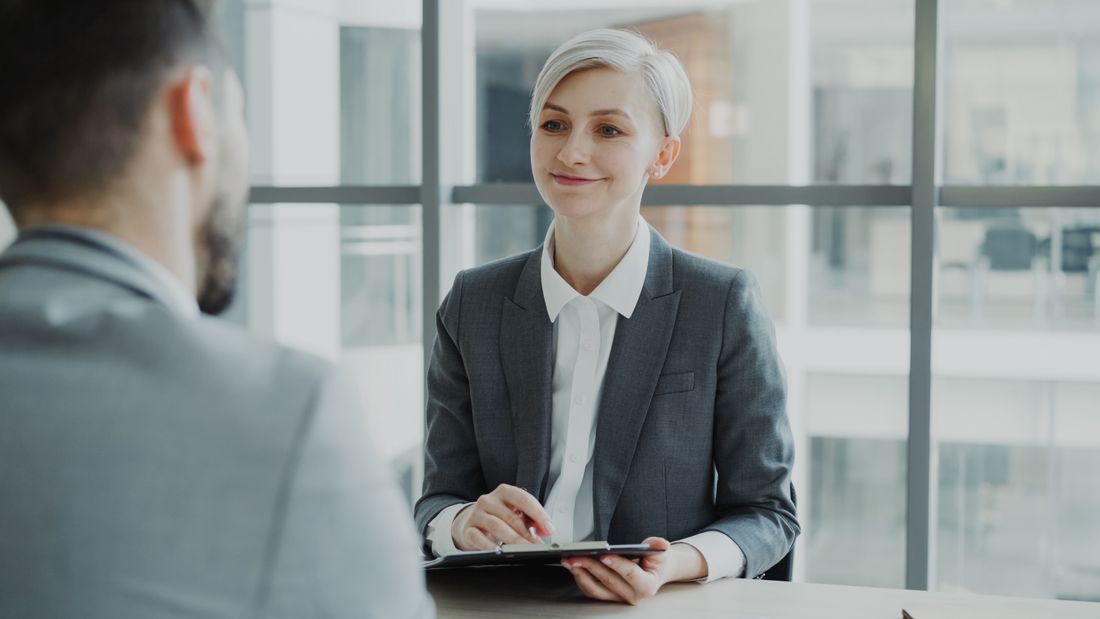 A candidate speaking with an interviewer in a bright office